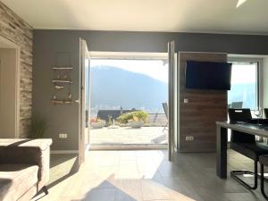 a living room with a sliding glass door with a view at Ferienwohnung Sonnenterrasse, 1-4 Personen, 2 Schlafzimmer, große Terrasse in Müden