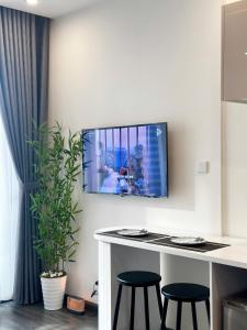 una TV a parete in una stanza con sgabelli di Trạm Sạc Homestay-Studio sang trọng-Lãng mạn-Tầng cao views đẹp-Netflix chill a Phú Thú