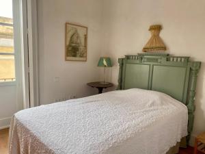 une chambre avec un lit avec une tête de lit verte et une lampe dans l'établissement CASA PALACIO LAS MARÍAS by Andalusian Glory, à Cadix 34 autres photos