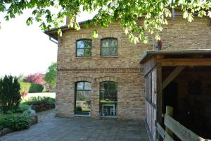 a brick house with windows and a driveway at 75 qm Ferienwohnung für 4 Personen am Naturschutzgebiet Anklamer Stadtbruch in Bugewitz