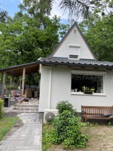 a white house with a window and a bench at BB-LAK víkend in Szigetmonostor