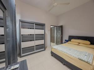 a bedroom with a bed and a large window at Hi-Tea HomeStay in Sungai Petani