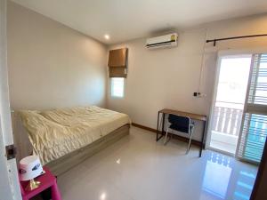 チェンライにあるQuality town home at Chiangraiのベッドと机と窓のある寝室