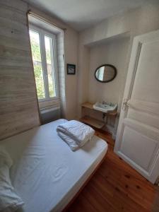 Schlafzimmer mit einem Bett, einem Fenster und einem Waschbecken in der Unterkunft Agréable maison de ville avec cheminée in Luchon