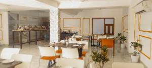 古尔冈Hotel Mavens House Artemis Hospital Road的一间带桌子和白色椅子的餐厅
