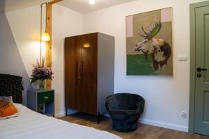ein Schlafzimmer mit einem Bett, einem Stuhl und einem Gemälde in der Unterkunft Drzemka in Ruda + 61 Fotos