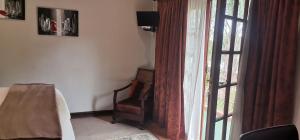 a living room with a chair and a window at Giardino a 194 in Welkom