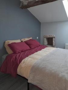 a bedroom with a large bed with red pillows at Maison bourguignonne in Lugny