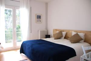 a bedroom with a large bed with a blue blanket at VILLA Mar y Montaña in Castelldefels