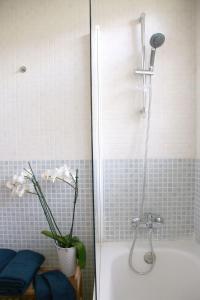 a bathroom with a shower with a vase of flowers at VILLA Mar y Montaña in Castelldefels +31 photos
