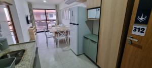 a kitchen with a refrigerator and a kitchen with a table at Apartamento aconchego Atalaia in Luis Correia