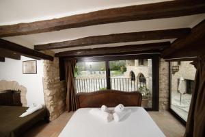 a bedroom with a bed and a large window at Ariqus Rural Cal Roc in Fontcuberta