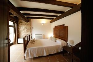 a bedroom with a white bed in a room at Ariqus Rural Cal Roc in Fontcuberta +1 photo