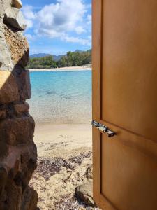 an open door to a beach with the ocean at Villa Di Fiore - private villa up to 10 guests with pool sauna and gym in Geremeas +47 photos