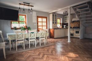 a kitchen and dining room with a table and chairs at Przystanek Jeziorna 49 in Perlino