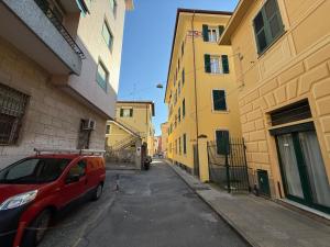 a red van parked on a street between two buildings at House Farorosmarino by Holiday World in Chiavari