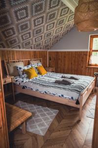 a bedroom with a bed with a wooden wall at Przystanek Jeziorna 49 in Perlino