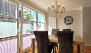 a dining room with a table and chairs and a chandelier at Warnemünde Strandnest 24350 in Warnemünde