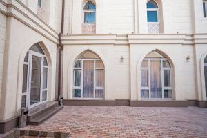 a building with three arched windows and a brick courtyard at The Wood Hotel & Spa near Magic City in Tashkent