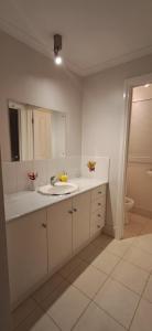Un baño blanco con lavabo y espejo. en south Brighon 4 mins to beach near cafe shops, en Brighton