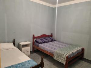 ein kleines Schlafzimmer mit 2 Betten und einem Nachttisch in der Unterkunft Costanera in Cafayate