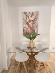 Un comedor con una mesa de cristal y sillas blancas. en Vivienda Turística La Cordobesa, en Córdoba
