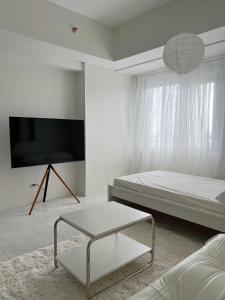a white room with a bed and a table at Cloud Space Studio near Eastwood in Manila