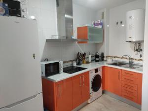 a kitchen with orange cabinets and a white refrigerator at Apartamento torrox in Torrox Costa