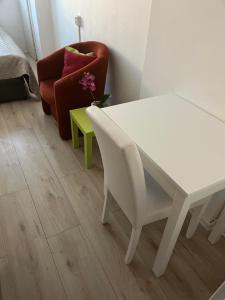 a white table and a chair in a room at Budget Single Room Old Town in Košice