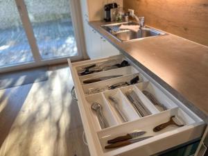 una cucina con lavandino e cassetto con utensili di Duo - ONE & TWO, Premium Apartments Seekirchen a Seekirchen am Wallersee Altre 43 foto