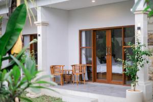 a patio with a table and chairs and a bed at Kemuning Living Sanur in Sanur