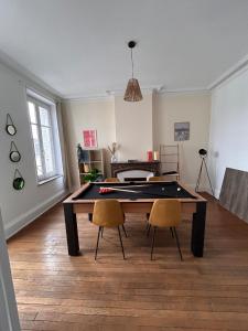 a living room with a ping pong table and two chairs at Bel appartement centre gare in Nancy