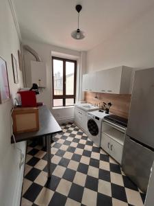 a kitchen with a black and white checkered floor at Bel appartement centre gare in Nancy +32 photos