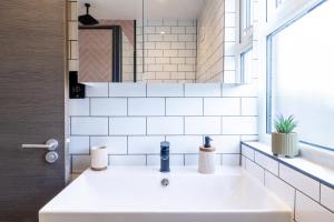 a bathroom with a white sink and a mirror at The Stanley in Teddington