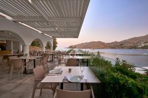 a restaurant with tables and chairs and a view of the ocean at Lindos Royal Resort in Líndos