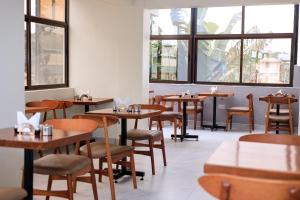 MeruCanopy View Hotel的有木桌椅和窗户的餐厅