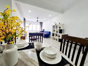 a dining room with a table and a vase of yellow flowers at Koi Kinrara 3 Room Sunway Pyramid Lagoon Hospital IOI Puchong Jaya Old Klang Road in Puchong