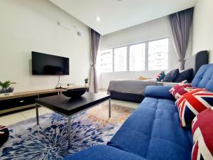 a living room with a blue couch and a tv at Koi Kinrara 3 Room Sunway Pyramid Lagoon Hospital IOI Puchong Jaya Old Klang Road in Puchong