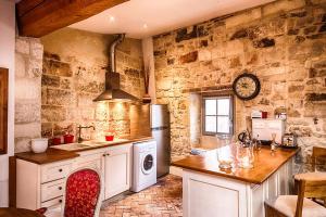 a kitchen with a stove and a sink and a refrigerator at Maison de Fogasses in Avignon