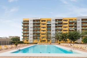 a swimming pool in front of a large apartment building at Home2Book Urban Retreat & Shared Pool Las Palmas in Las Palmas de Gran Canaria