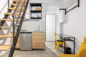 eine Küche mit Treppe, Tisch und gelben Stühlen in der Unterkunft Boho Rooms in Thessaloniki