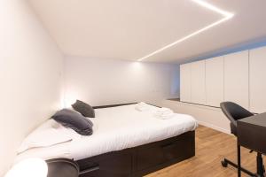 a bedroom with a bed with white walls and a desk at New Luxury Loft - Prada-Bocconi in Milan +8 photos