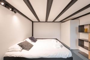 a bedroom with a white bed with a black frame at New Luxury Loft - Prada-Bocconi in Milan