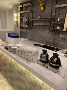 a kitchen counter with dishes and appliances on it at Star Hotel Chiang Mai in Chiang Mai