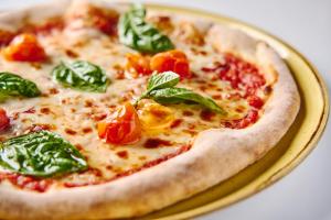 a pizza sitting on a plate on a table at Lindos Royal Resort in Líndos