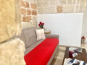 a living room with a couch with a red blanket at Antica Pietra in Polignano a Mare