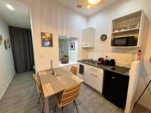 eine Küche mit Tisch und Esszimmer in der Unterkunft Le Nid en Rotin Apartment in Montbéliard + 4 Fotos