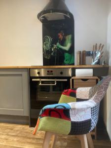 Ein Mann steht vor einem Herd in einer Küche in der Unterkunft Gavin's Sea Pad in St. Leonards