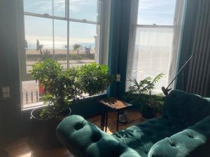 ein Wohnzimmer mit Couch und großem Fenster in der Unterkunft Gavin's Sea Pad in St. Leonards