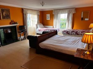 a bedroom with two beds and a fireplace at The Old Farmhouse in Dalkeith +4 photos